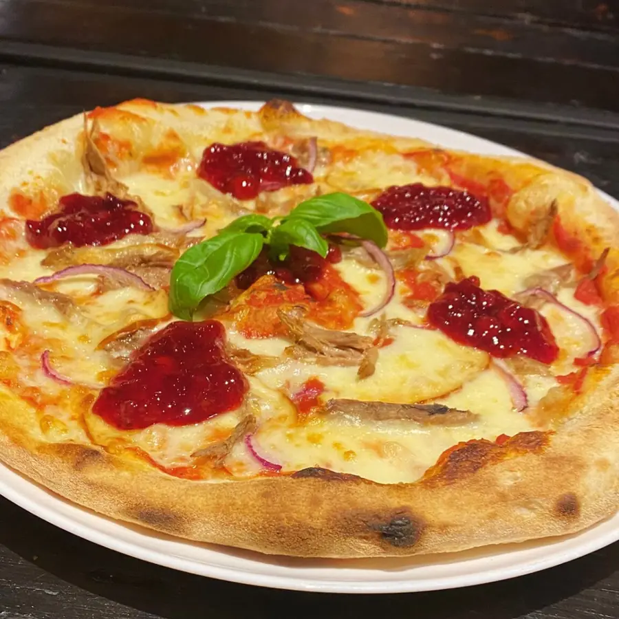 Pizza z żurawiną, czerwoną cebulą i bazylią.